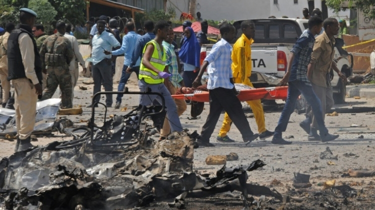Des somaliens portent une femme blessée dans un attentat à la voiture piégée, le 31 juillet à Mogadiscio