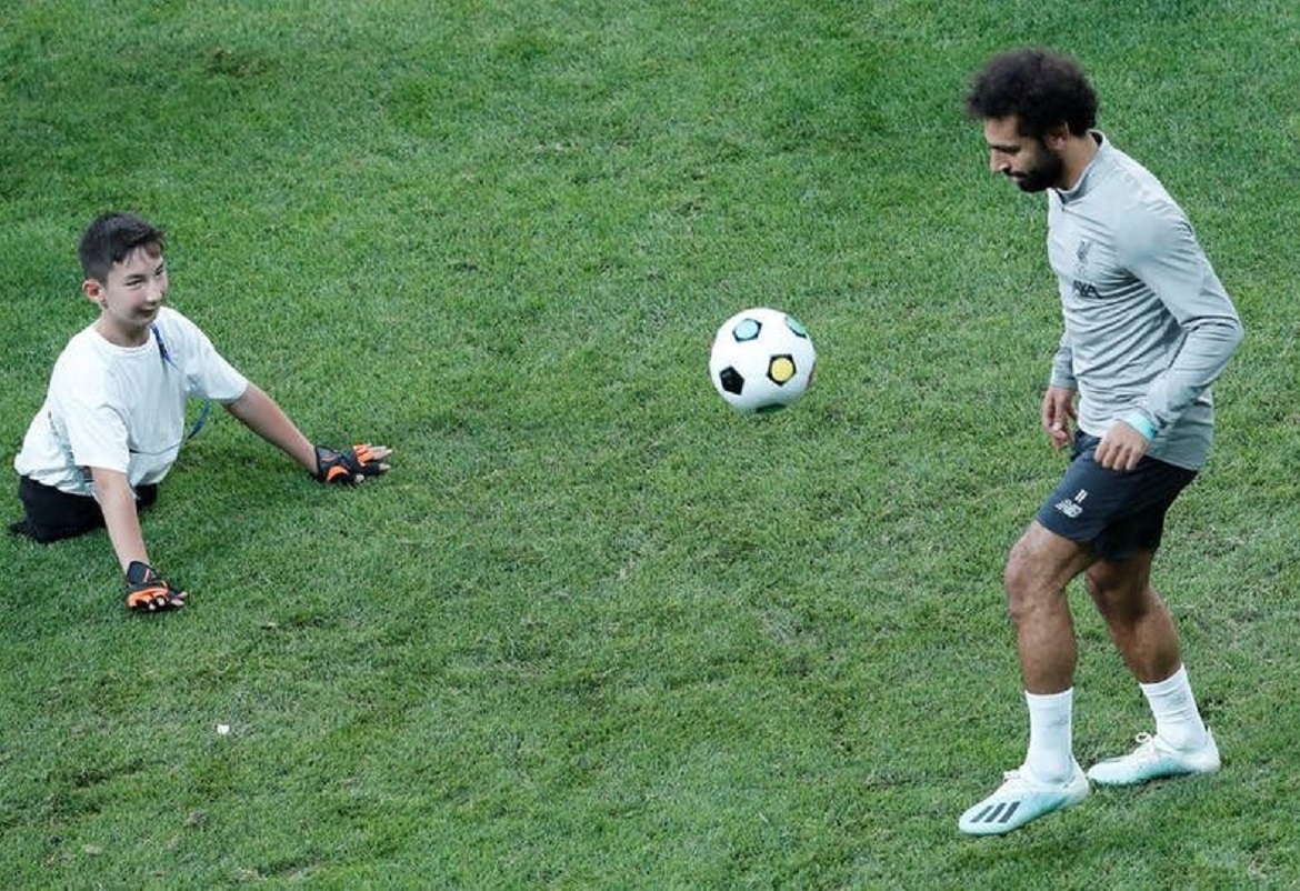 محمد صلاح يلعب الكرة مع طفل من ذوي الاحتياجات الخاصة