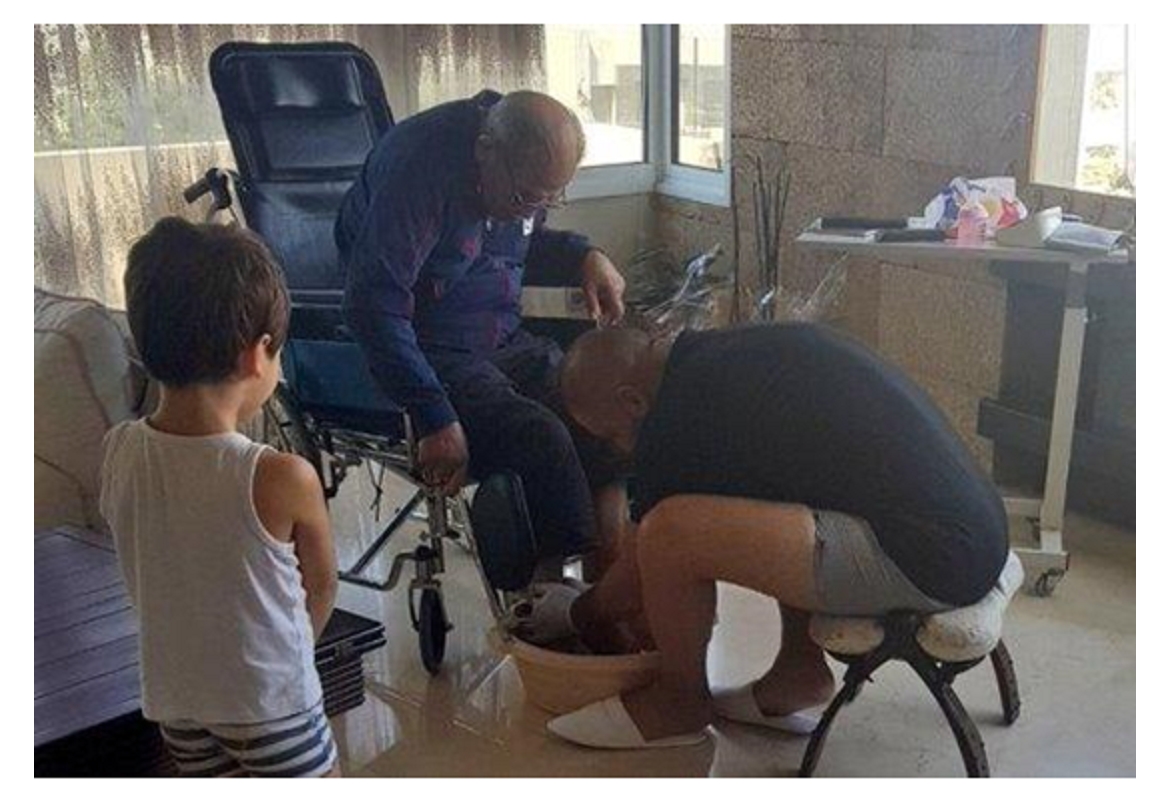 وبالوالدين إحسانًا.. صورة مؤثرة لفنان شهير مع والده المصاب بالشلل